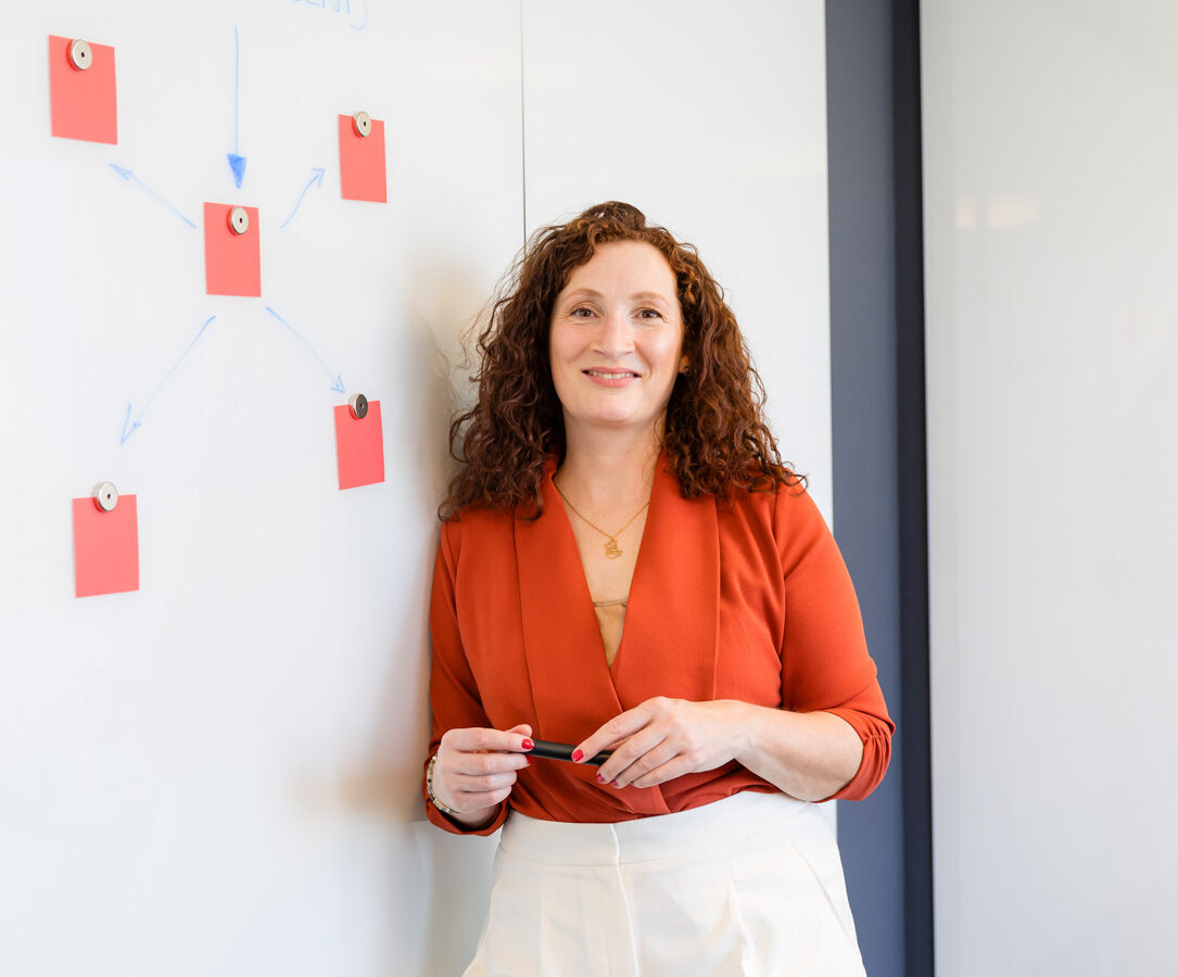 Praxisnahe und verständliche Rechtsberatung für Startups, E-Commerce und Tech-Unternehmen. Klarissa Rother – Anwältin für Digitales bei Rother Legal, lehnt an einem Whiteboard – praxisnahe Rechtsberatung für Unternehmen und Startups.